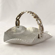 Load image into Gallery viewer, This sweet vintage mid-century hammered aluminum basket is embossed in the &quot;Tulip&quot; pattern and features a decorative ribbon style handle detailed with flowers. Crafted by Rodney Kent, USA. In good vintage condition. Unmarked. Measures 7 x 5 3/4 x 4 inches
