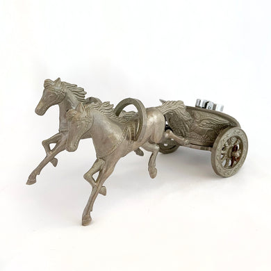 Unique and highly collectible vintage mid-century Roman horse drawn chariot table light made with cast silver-toned metal with chrome lighter. Definitely a conversation piece!  Chariot swivels, but we're unsure whether or not it's a flaw. Otherwise in great vintage condition with nice patina. Lighter needs flint and lighter fluid or butane post-shipping. Unmarked.  Measures 7-1/2