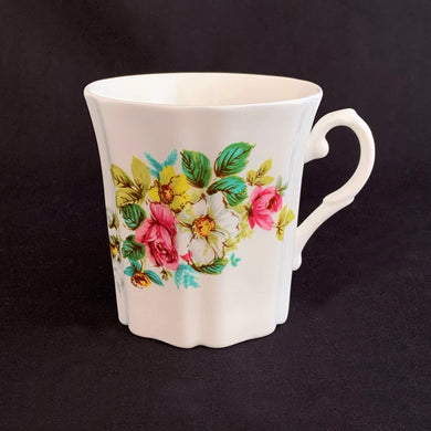 Treat yourself to a cuppa in this lovely feminine shaped fine bone china mug featuring beautiful bouquet of white, yellow and pink roses with green leaves on white bone china. Crafted by Royal Grafton, England, circa 1970s. Grafton made these mugs with many floral designs — collect them all!  In excellent condition, no chips, cracks or crazing. Marked on the bottom with 