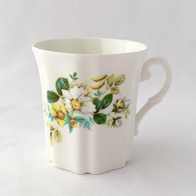 Treat yourself to a cuppa in this lovely feminine shaped fine bone china mug featuring beautiful white and yellow flowers with green leaves on white bone china. Crafted by Royal Grafton, England, circa 1970s. Grafton made these mugs with many floral designs — collect them all!  In excellent condition, no chips, cracks or crazing. Marked on the bottom with 