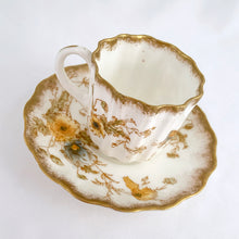 Load image into Gallery viewer, Antique Rutland demitasse cup and saucer, with blue and yellow flowers trimmed in gold gilt. Produced by Doulton Burslem, England, circa 1900. In excellent condition, free from chips, cracks, repairs. Cup stamped green DOULTON BURSLEM ENGLAND, red hand painted mark 66254 with three lines crossed out below. Saucer stamped with brown DOULTON BURSLEM ENGLAND and RUTLAND Rd 168550 U.S.PATENT, red hand painted mark 66154 with a 9 below. Cup 2-1/8&quot; x 2-1/8&quot; and saucer approximately 4&quot;
