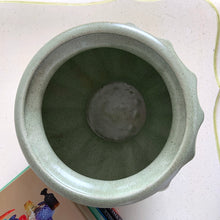 Load image into Gallery viewer, The sage green colour with tiny brown flecks is perfection on this round Grecian style urn round planter. Produced by Haeger U.S.A. for FTD, circa 1970. Fill this beauty with houseplants, succulents or a beautiful bouquet of flowers. Whatever you choose it&#39;ll make a fabulous addition to your décor. In excellent condition, no chips or cracks. Stamped on the bottom with DESIGNED EXCLUSIVELY FOR FLORISTS TELEGRAPH DELIVERY ASSOCIATION, HAEGER USA. Measures 6 1/4 x 6 1/2 inches
