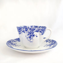 Load image into Gallery viewer, Absolutely stunning vintage bone china &quot;Dainty Blue&quot; tea cup and saucer. Produced by Shelley in England between 1938.  In excellent vintage condition, free from chips/cracks/crazing. Appears to be unused.  Tea cup measures 3-3-8&quot; x 2-1/4&quot; | marked &quot;051/28&quot;  Saucer measures 5-1/2&quot; | marked &quot;051/28&quot;
