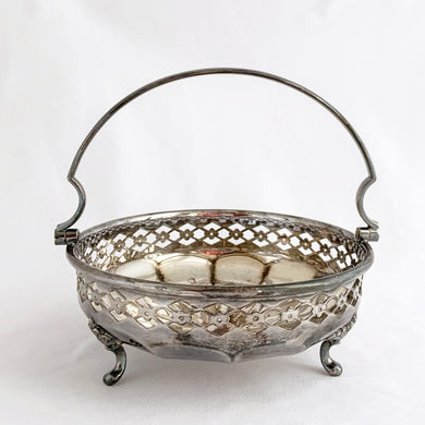 Beautiful vintage EPNS silver plated basket with pierced detail band on a rosette bottomed bowl with three feet and handle. Produced by JT & Co., Sheffield England.  In good vintage as found condition. Marked on the bottom 
