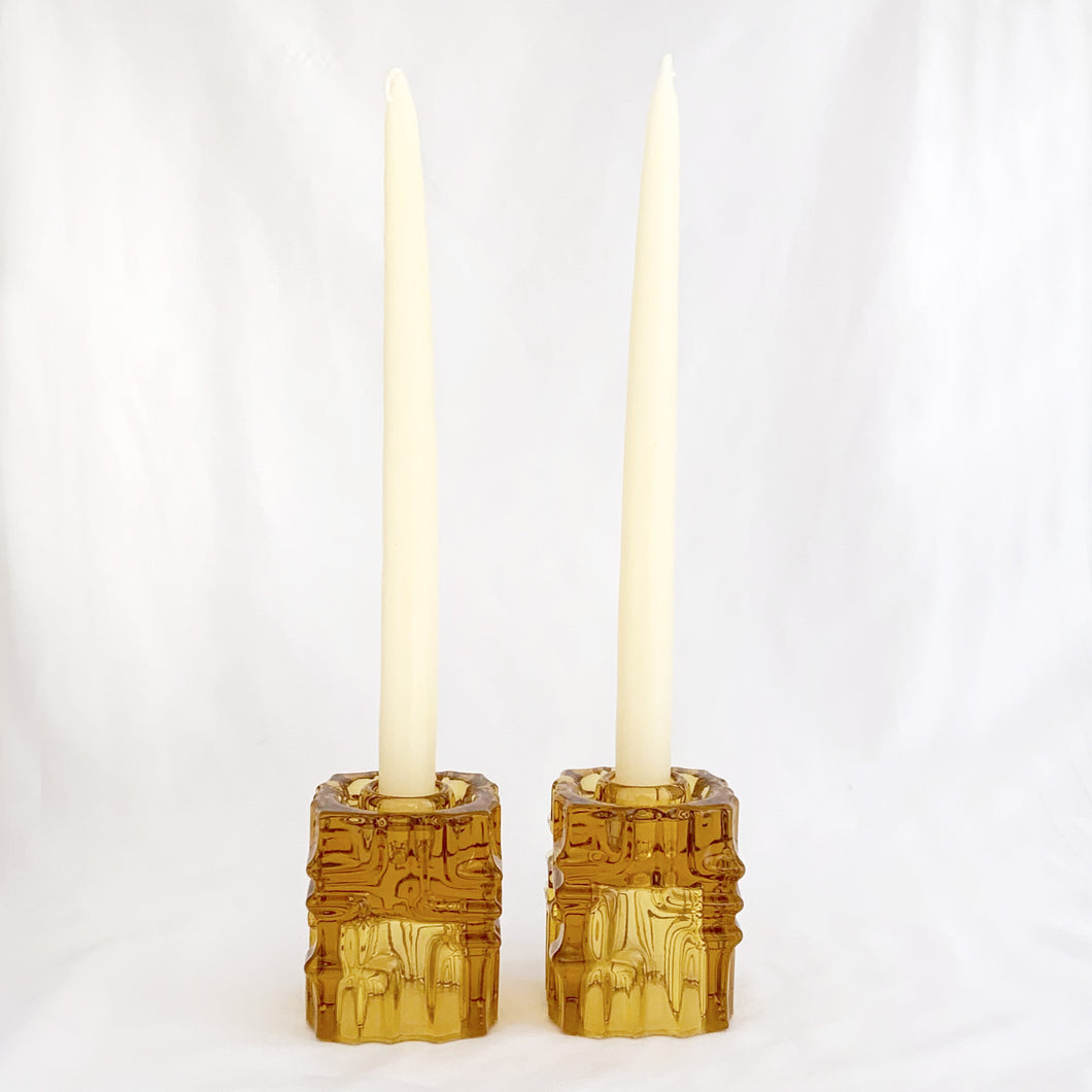 Stunning pair of vintage mid-century bohemian amber candle holders made of mold-blown glass with a brutalist design. These can be used for tapers on one side and votive candles on the other side. Designed by glass and jewellery artist Vladislav Urban for Sklo Union during his tenure at Rosice Glassworks, Czechoslovakia, circa 1968.   In excellent condition, free from chips/cracks.  Measures 2 3/8 x 2 3/8 x 3 1/8 inches