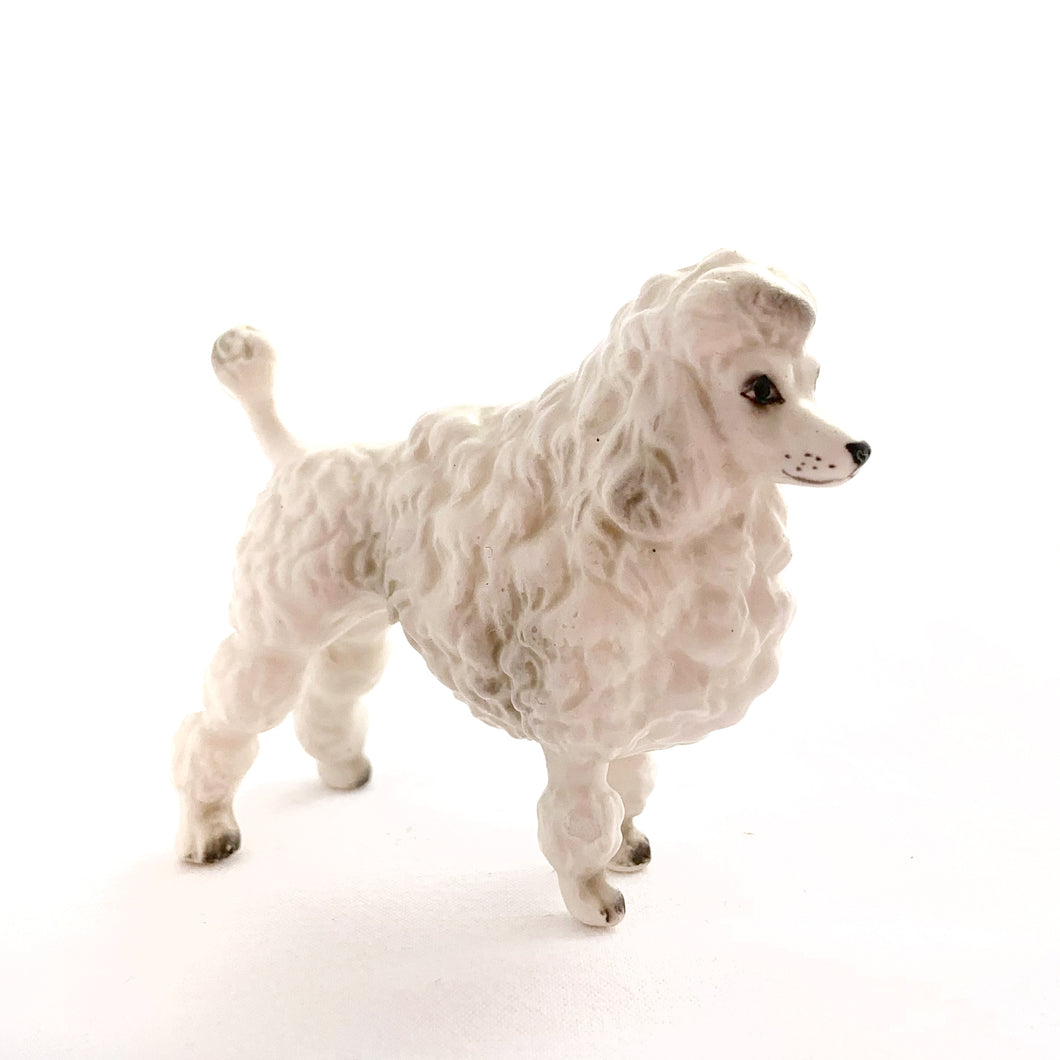 Sweet miniature porcelain figurine of a standing white poodle with hand painted details.  In excellent condition, no chips or cracks.  Measures approximately 1