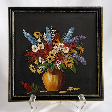 A still life oil painting on glass depicting an amber vase filled with blue purple Delphinium, red Cardinal, yellow Black Eyed Susan, white daisy flowers back painted in black. Signed by the artist IRI in the lower right corner. This painting is framed in a gold tone and black wood frame.  In excellent condition.  DImensions: 8