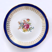 Load image into Gallery viewer, This vintage bone china teacup and saucer is absolutely stunning! Both the cup and saucer are glazed in white with a blue band, gold geometric pattern and rim with a central bouquet of colourful flowers. Produced by Royal Grafton, England, circa 1950 - 1956.  In excellent condition, free from chips, cracks and repairs. Pattern number 1781 marked on the bottom of the teacup.  Teacup measures 3-7/8&quot; x 2&quot;  | Saucer measures 5-5/8&quot;
