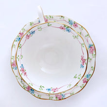 Load image into Gallery viewer, Antique bone china footed teacup and saucer with scalloped edge, hand painted whimsical pastel coloured foxglove florals and rimmed with gold gilt. Produced by Royal Albert, England, circa 1917 - 1927. In excellent condition, free from chips, cracks and repairs. Pattern number 2475 and maker&#39;s marks are on the bottom of the teacup and maker&#39;s mark on the saucer. Teacup measures 3-3/4&quot; x 2-3/8&quot; | Saucer measures 5-1/2&quot;
