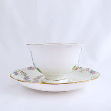 Load image into Gallery viewer, This antique bone china footed teacup and saucer is so sweet! Both the cup and saucer have a lovely scalloped edge with hand painted whimsical pastel coloured foxglove flowers and rimmed with gold gilt. Produced by Royal Albert, England, circa 1917 - 1927. In good condition.  Teacup measures 3 3/4 x 2 3/8 inches  | Saucer measures 5 1/2 inches
