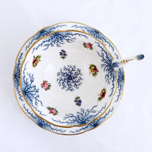 Load image into Gallery viewer, Antique bone china teacup and saucer with scalloped edge and decorated with hand painted pansies and roses with a blue graphic plant and rimmed with gold gilt. Produced by Coalport, England, circa 1900. In good condition, free from chips, cracks and repairs. Manufacturer&#39;s defect to the right of the handle at the rim. Pattern number 8252 and maker&#39;s marks are on the bottom of the teacup and maker&#39;s mark on the saucer. Teacup measures 4&quot; x 2-1/8&quot; | Saucer measures 5-3/4&quot;
