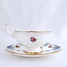 Load image into Gallery viewer, Antique bone china teacup and saucer with scalloped edge and decorated with hand painted pansies and roses with a blue graphic plant and rimmed with gold gilt. Produced by Coalport, England, circa 1900. In good condition, free from chips, cracks and repairs. Manufacturer&#39;s defect to the right of the handle at the rim. Pattern number 8252 and maker&#39;s marks are on the bottom of the teacup and maker&#39;s mark on the saucer. Teacup measures 4&quot; x 2-1/8&quot; | Saucer measures 5-3/4&quot;
