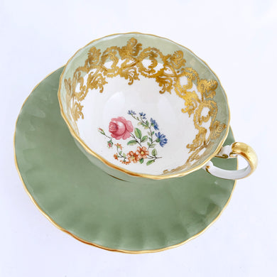 vintage bone china teacup and saucer with a lovely scalloped shape. The cup is a lovely shade of celadon green, interior celadon band is overlaid with a complex gold pattern with a central bouquet of colourful flowers. Saucer is celadon green with a white centre and gold gilt rim. Produced by Aynsley, England, circa 1939. In excellent condition, free from chips, cracks and repairs. Pattern number C1557 with maker's marks. Teacup measures 3-1/2