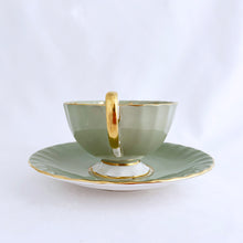 Load image into Gallery viewer, vintage bone china teacup and saucer with a lovely scalloped shape. The cup is a lovely shade of celadon green, interior celadon band is overlaid with a complex gold pattern with a central bouquet of colourful flowers. Saucer is celadon green with a white centre and gold gilt rim. Produced by Aynsley, England, circa 1939. In excellent condition, free from chips, cracks and repairs. Pattern number C1557 with maker&#39;s marks. Teacup measures 3-1/2&quot; x 2-1/4&quot;  | Saucer measures 5-5/8&quot;
