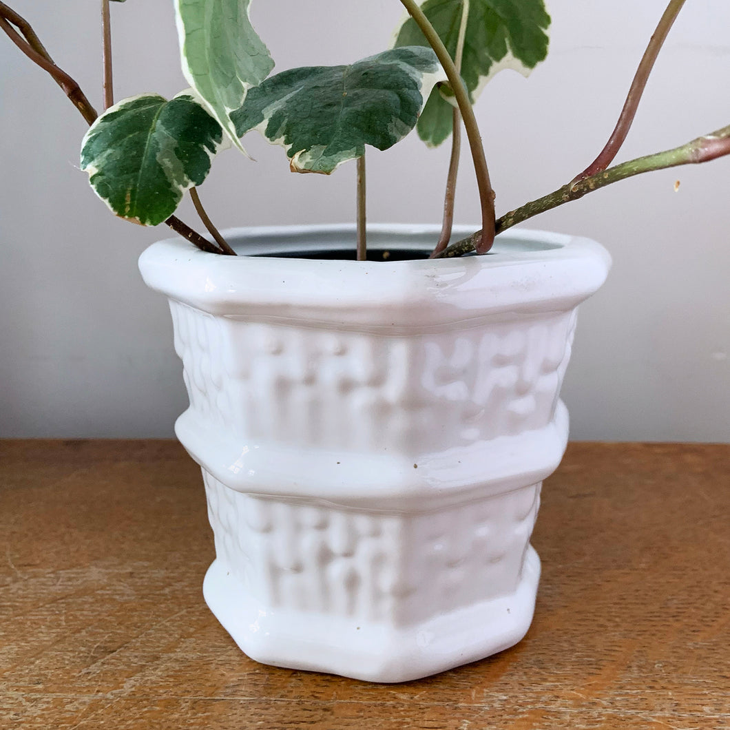 Vintage eight panel white ceramic planter with a basketweave pattern bordered with thick bands. Produced in Canada.  In excellent condition, free from chips/cracks. Marked on the bottom, but we are unable to decipher except for the word 