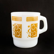 Load image into Gallery viewer, Vintage milk glass mug with vibrant gold atomic cloud or flower and graphic key at the rim. Produced by Anchor Hocking Glass Co. Circa 1970.  In excellent condition free from chips/cracks/wear.  Measures 3 x 3 3/8 inches  Capacity 8 ounces 
