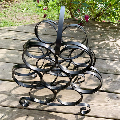 This vintage seven bottle wine rack is a perfect addition to any home. The black wrought iron construction is both stylish and sturdy, perfect for securely storing your favorite wines. Ideal to place on a countertop, buffet or floor.  In excellent condition, with all welds intact.  Measures 12 1/2 x 9 x 16 1/2 inches