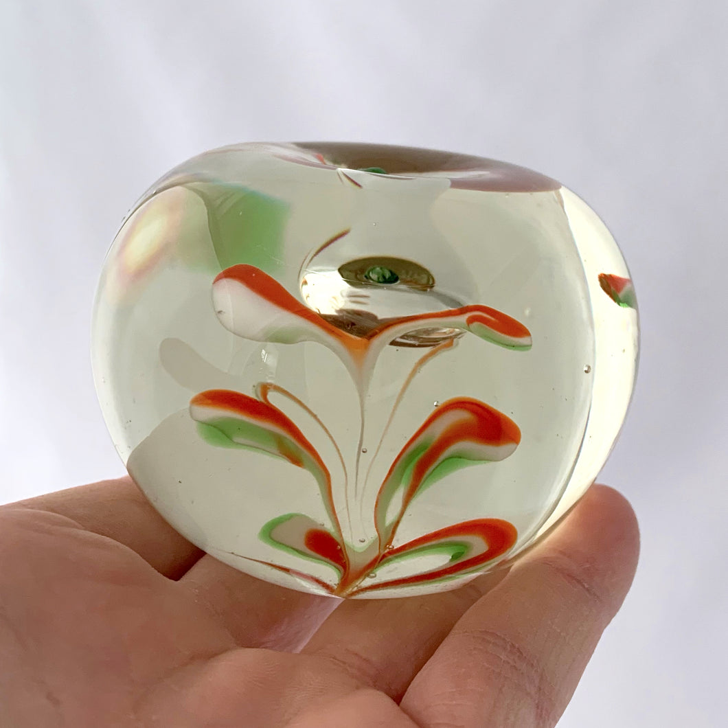 Red, green and white swirls form an iris flower inside this hand blown apple shaped paperweight with green stem. The bottom has a smoothened pontil mark. Unsigned.   In excellent condition, no chips or cracks.  Size: 3