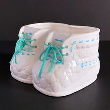 Load image into Gallery viewer, This super cute vintage planter is perfect for a nursery. White baby booties planter with real laces and blue stitch detail. Perfect for a succulent, or use to store baby accessories.  Marked on the bottom with a &#39;G&#39; in a circle, sticker with Made in Taiwan, but could have been made in Japan.  Excellent condition, no chips or cracks.  Size: 5.5&quot; x 4.5&quot; x 3.5&quot;
