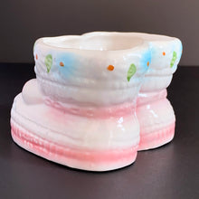 Load image into Gallery viewer, Vintage Nancy Pew Giftware white baby booties planter with pink bows and edge details, plus white and blue daisy flowers around the rim. ADORABLE!  Marked on the bottom with Nancy Pew&#39;s &#39;bell&#39; symbol and &#39;Made in Taiwan&#39; sticker, but could have been made in Japan.  Excellent condition, no chips or cracks.  Size: 4&quot; x 4&quot; x 3&quot;
