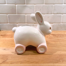 Load image into Gallery viewer, Vintage White Bunny Rabbit Coin Bank Imported by Eaton Made in Taiwan Pink Wheels Pull Toy Bow Blue Flowers Child Home Decor Kid Room Nursery Savings Kitsch Money Black Rubber Stopper Home Decor Boho Bohemian Shabby Chic Cottage Farmhouse Victorian Mid-Century Modern Industrial Retro Flea Market Style Unique Sustainable Gift Antique Prop GTA Hamilton Toronto Canada shop store community seller reseller vendor
