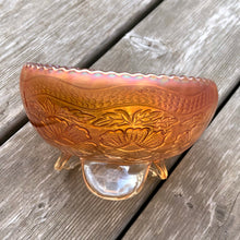 Load image into Gallery viewer, This vintage &quot;Two Flowers&quot; marigold carnival glass bowl features an intricate design of dogwood flowers and marsh lilies, a smooth sawtooth rim and three spatulate feet. Crafted by Fenton Art Glass, early 20th century. The iridescence on this bowl is outstanding and it&#39;s sure to become a treasured piece.  In excellent condition with free from chips. Unmarked.  Measures 6 1/4 x 3 1/2 inches
