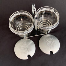 Load image into Gallery viewer, A great mid century glass and aluminum lidded condiment set made by the Libbey Glass Company, USA, circa 1950s. The glass containers each having a black and white design. They fit nicely into their metal caddy with aluminum lids decorated with pinecones that fit atop each glass jar.  The set is in excellent condition.  The caddy measures about 6 1/2 inches in length and 5 1/8 inches in height. 
