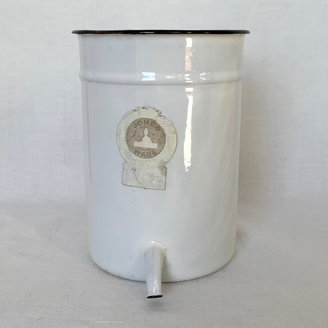 This vintage white and black enamel irrigator makes a perfect hanging container. Use as a planter, or to store garden tools. Has a hole on the back for hanging. Original Jones Ware label.