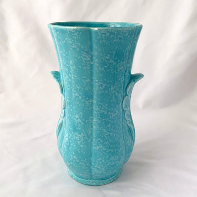 A lovely art deco style vintage vase in sky blue with white speckles. Adorned on either side with a dimensional leaf motif and subtle feminine fluted body. A beautiful vase to use as a decor piece or fill it with a beautiful bouquet of flowers!  In good vintage condition, 2 minor flea bites on the rim which aren't too noticeable thanks to the white speckled glaze. No cracks or repairs.  Measures 5 x 8 3/4 inches