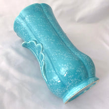 Load image into Gallery viewer, A lovely art deco style vintage vase in sky blue with white speckles. Adorned on either side with a dimensional leaf motif and subtle feminine fluted body. A beautiful vase to use as a decor piece or fill it with a beautiful bouquet of flowers!  In good vintage condition, 2 minor flea bites on the rim which aren&#39;t too noticeable thanks to the white speckled glaze. No cracks or repairs.  Measures 5 x 8 3/4 inches
