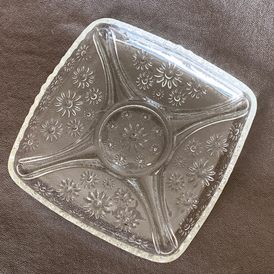 Sweet vintage clear pressed glass relish dish with embossed flowers and a sawtooth edge. Produced by the Hazel-Atlas Glass Company, circa 1950s. Perfect for candies, pre-dinner pickles or use as a trinket tray in your boudoir or bath.  In excellent condition, no chips or cracks.  Size: 6.25” x 6.25” x 1”