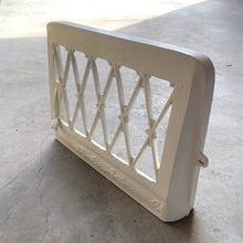 Load image into Gallery viewer, This antique cast iron heating vent register cover has been painted a creamy white. Use as intended in your home renovation project, or flip it upside down and attach it to the wall for a unique mail, magazine or newspaper holder.
