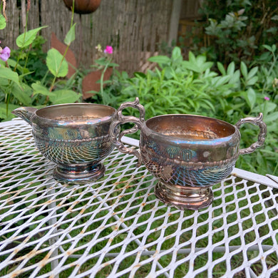 This is a wonderful two piece silver plate creamer and sugar bowl. Each piece is embellished with a rope design on the bowls and handles have a scroll detail. In excellent vintage condition with patina. Can be polished to a gleaming silver or left as is for a more aged look.  The sugar bowl measures 6 x 3 1/2 inches (with handles), the creamer measures 5 x 3 1/3 inches (with handles).  Creamer and sugar bowl are marked Viking Plate, Canada.